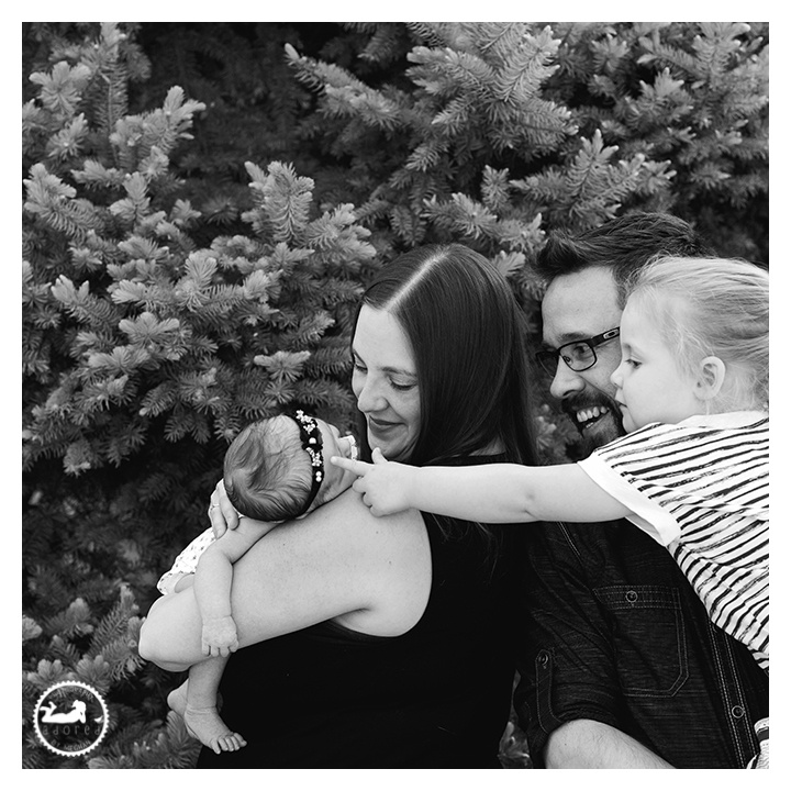 Black and white portrait of family with new baby sister