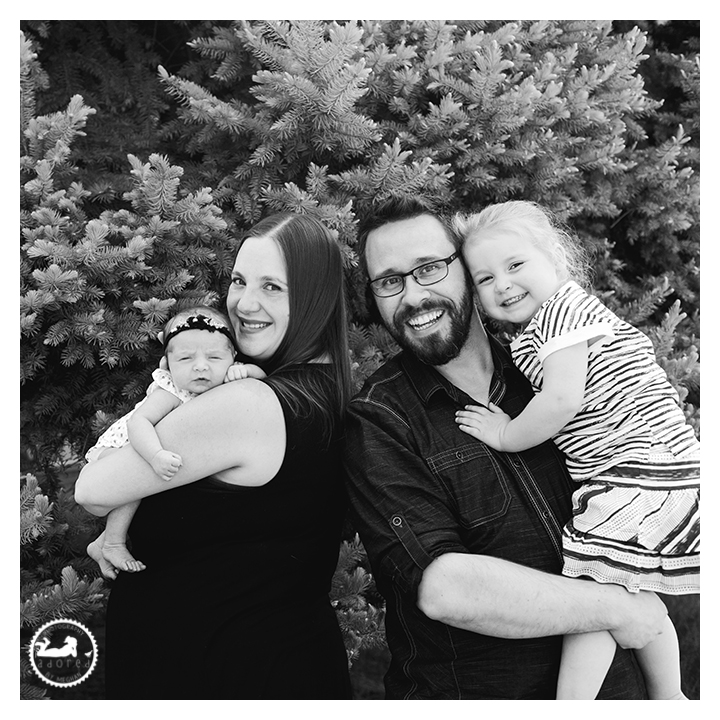 Black and white portrait of family with new baby sister